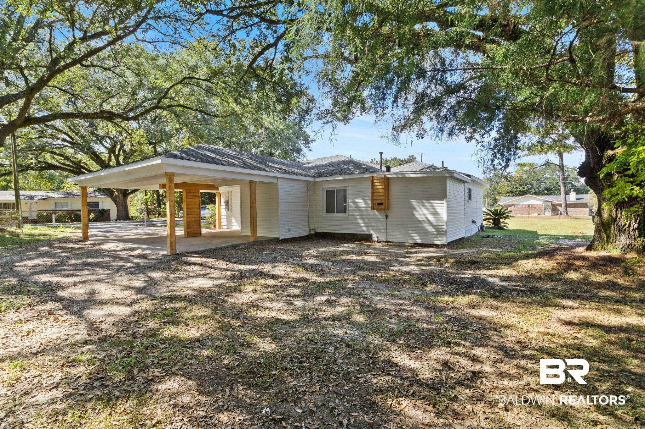 618 Pine Street Saraland, AL 36571 - Photo 25 of 41 Rear view of property featuring a patio and a carport