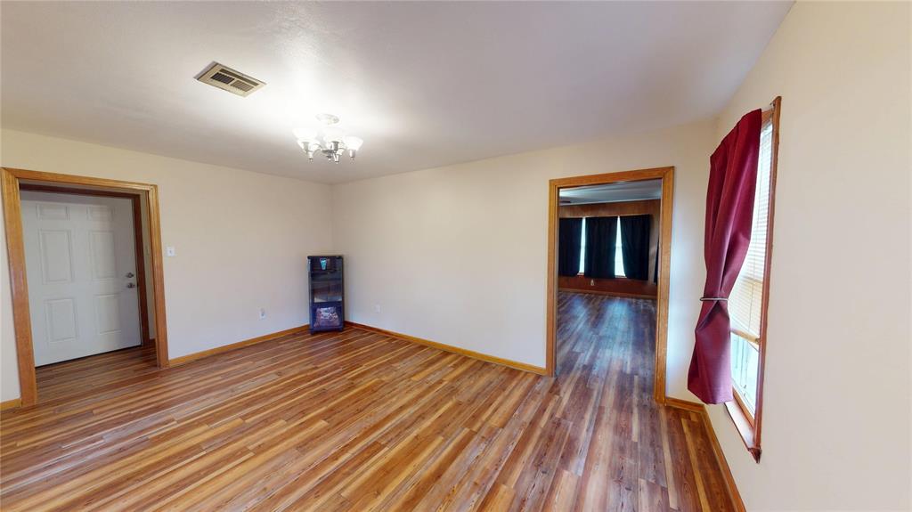 3125 McFerrin Avenue Waco, TX 76708 - Photo 11 of 36 Empty room featuring wood finished floors and a chandelier