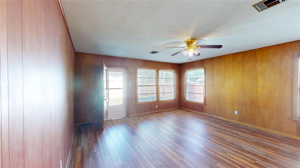 3125 McFerrin Avenue Waco, TX 76708 - Photo 12 of 36 Spare room featuring wood finished floors, wooden walls, and a ceiling fan