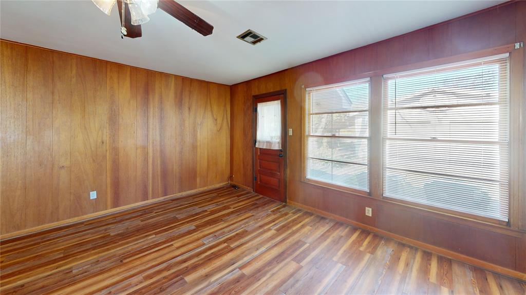 3125 McFerrin Avenue Waco, TX 76708 - Photo 13 of 36 Unfurnished room with wooden walls, a ceiling fan, and wood finished floors