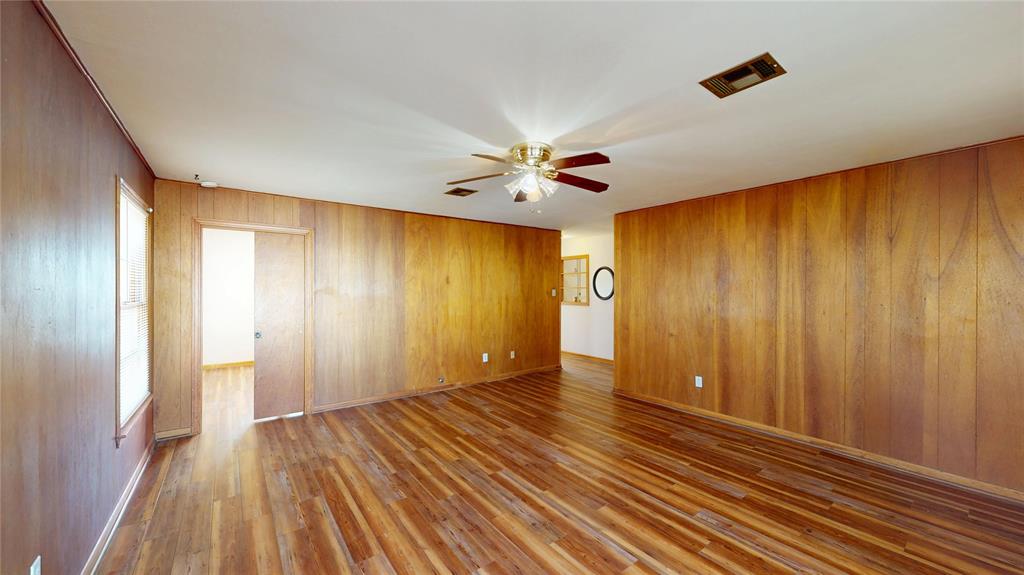 3125 McFerrin Avenue Waco, TX 76708 - Photo 15 of 36 Spare room featuring dark wood-type flooring, wooden walls, and ceiling fan