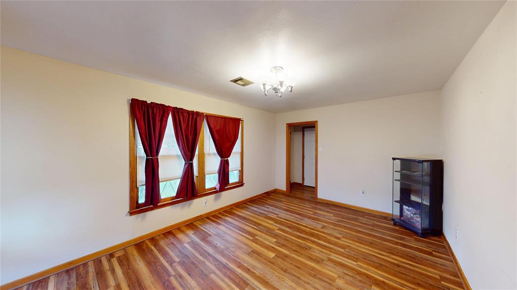 3125 McFerrin Avenue Waco, TX 76708 - Photo 9 of 36 Spare room featuring wood finished floors and a chandelier