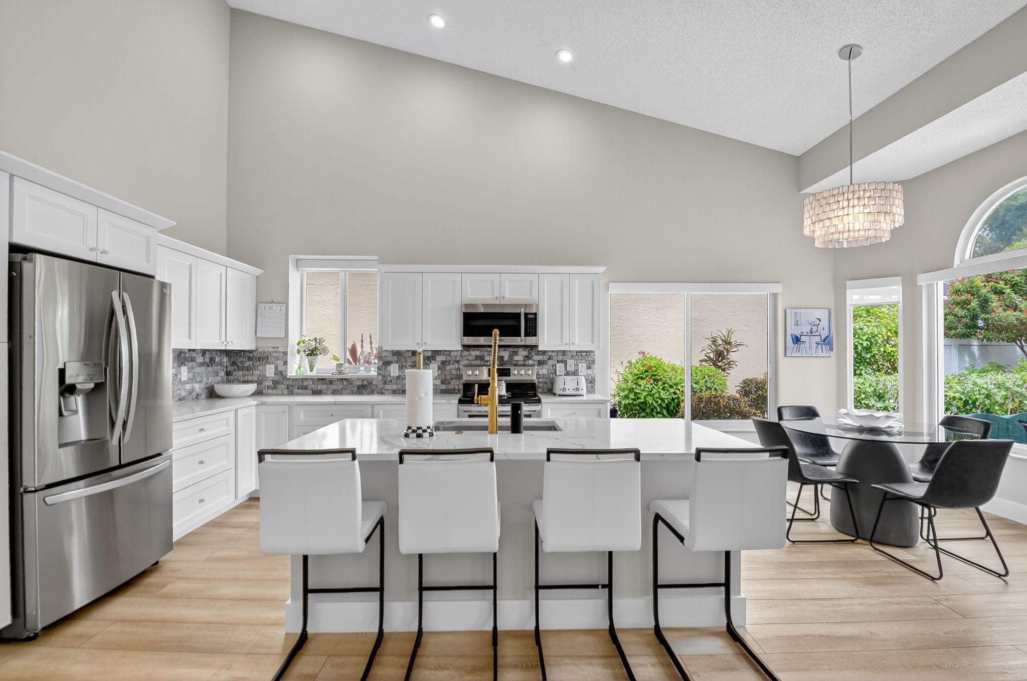 8385 Horseshoe Bay Road Boynton Beach, FL 33472 - Photo 9 of 49 a kitchen with a dining table chairs and refrigerator