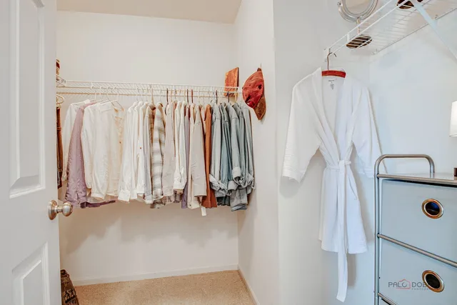 a view of walk in closet with clothes and shoes