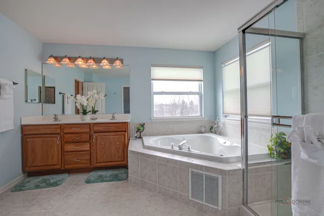 a spacious bathroom with a tub sink and mirror