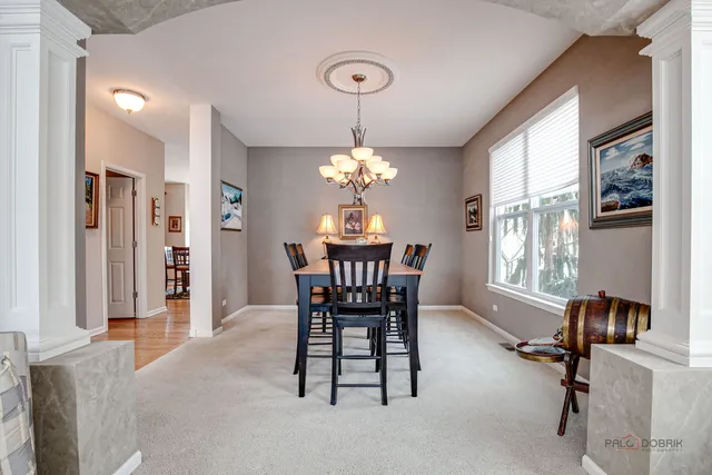 a dining room with furniture a chandelier and window