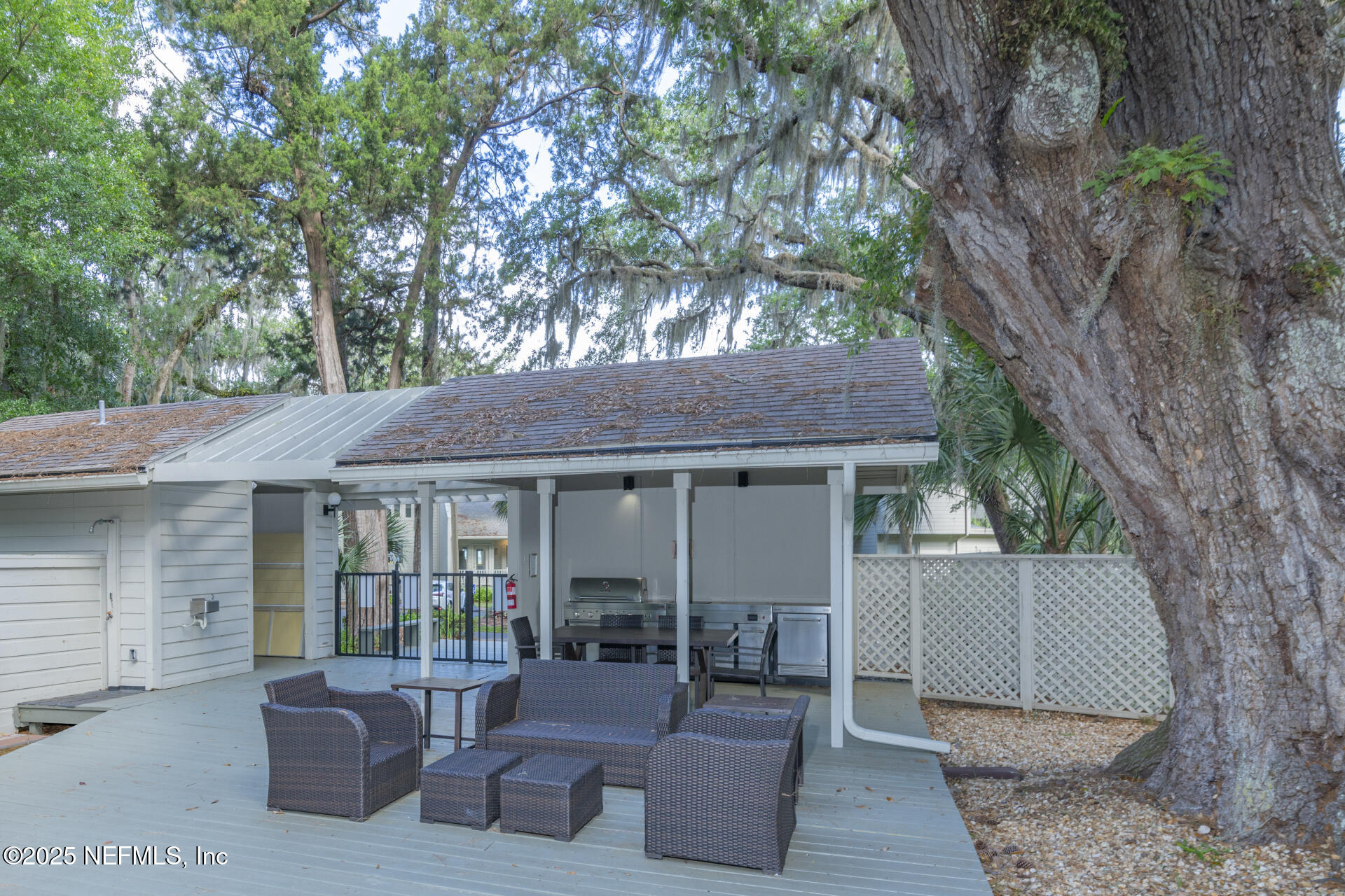3426 Sea Marsh Road Fernandina Beach, FL 32034 - Photo 5 of 39 a view of a patio with table and chairs and a large tree