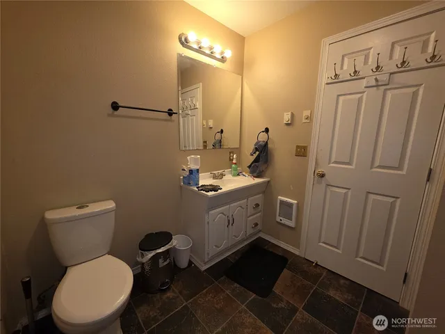 a bathroom with a toilet sink vanity and mirror