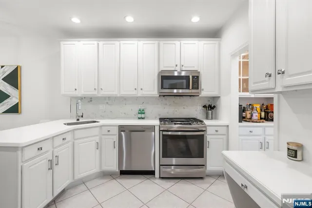 a kitchen with white cabinets and white appliances