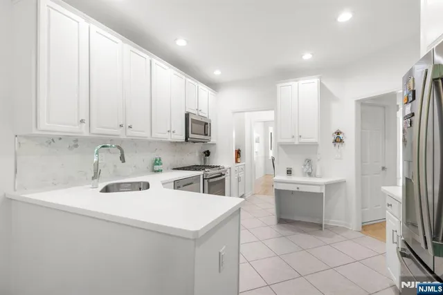 a kitchen with stainless steel appliances granite countertop a stove a sink dishwasher and a refrigerator