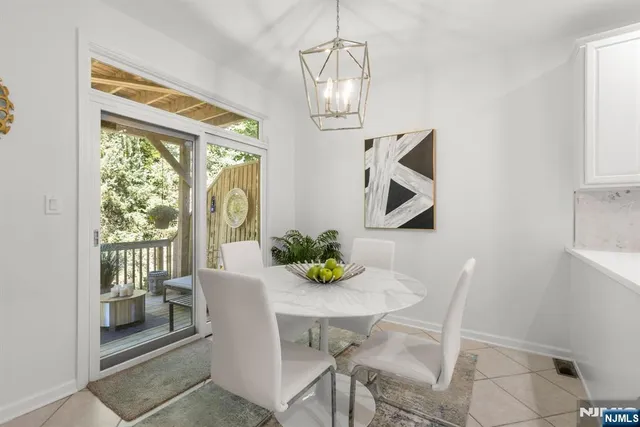 a kitchen with stainless steel appliances kitchen island granite countertop a dining table chairs and white cabinets