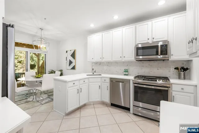 a kitchen with cabinets appliances a sink and a counter top space
