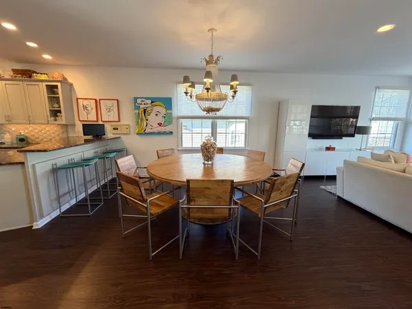 a dining room with furniture a chandelier and wooden floor