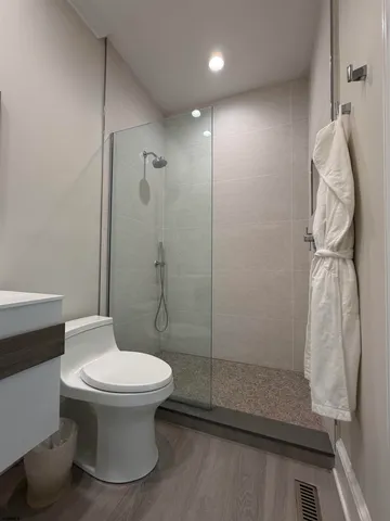 a bathroom with a toilet and a shower