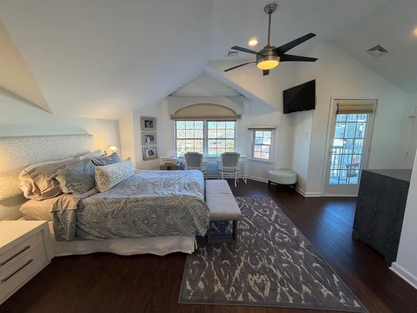 a spacious bedroom with a bed a couch and a chandelier