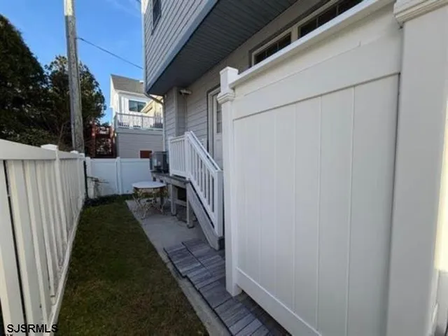 a backyard of a house with barbeque oven wooden fence and a bench