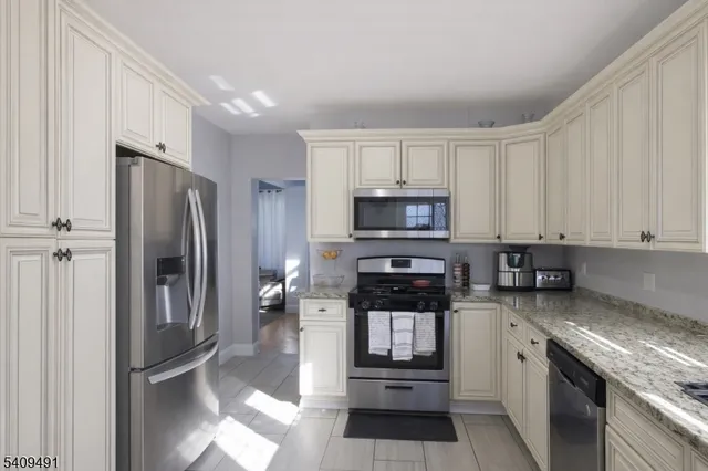 a kitchen with stainless steel appliances granite countertop a refrigerator stove and microwave