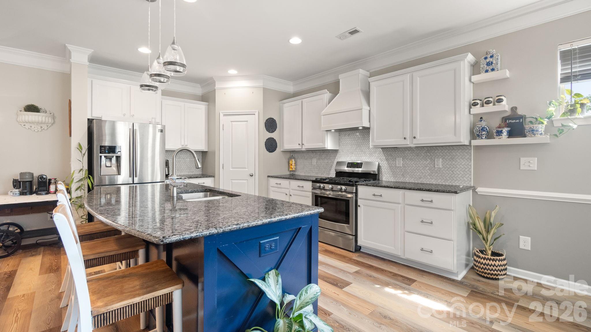 4708 Summerside Drive Clover, SC 29710 - Photo 16 of 48 a kitchen with kitchen island granite countertop a table chairs a sink dishwasher window and cabinets