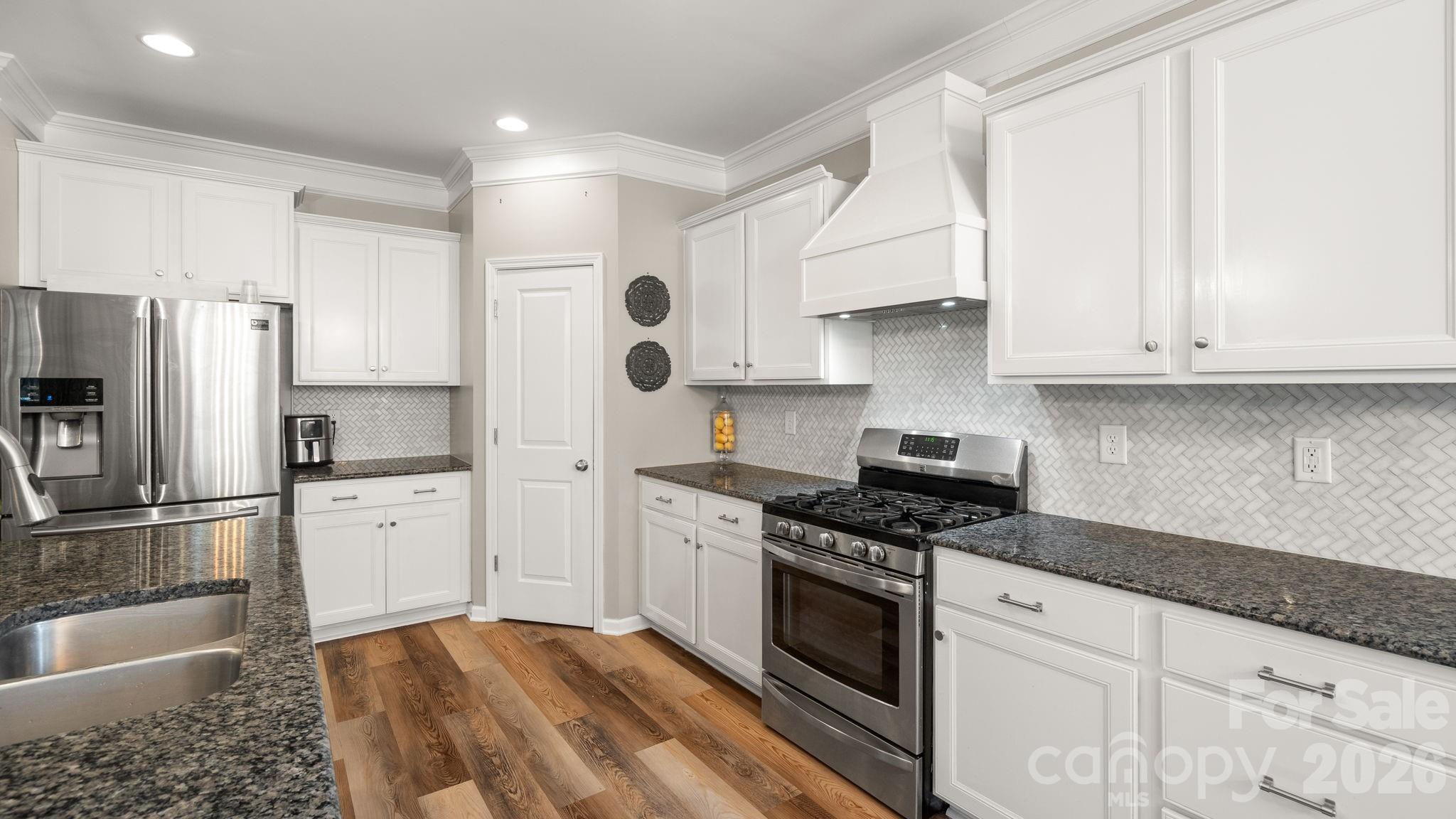 4708 Summerside Drive Clover, SC 29710 - Photo 20 of 48 a kitchen with granite countertop white cabinets and stainless steel appliances