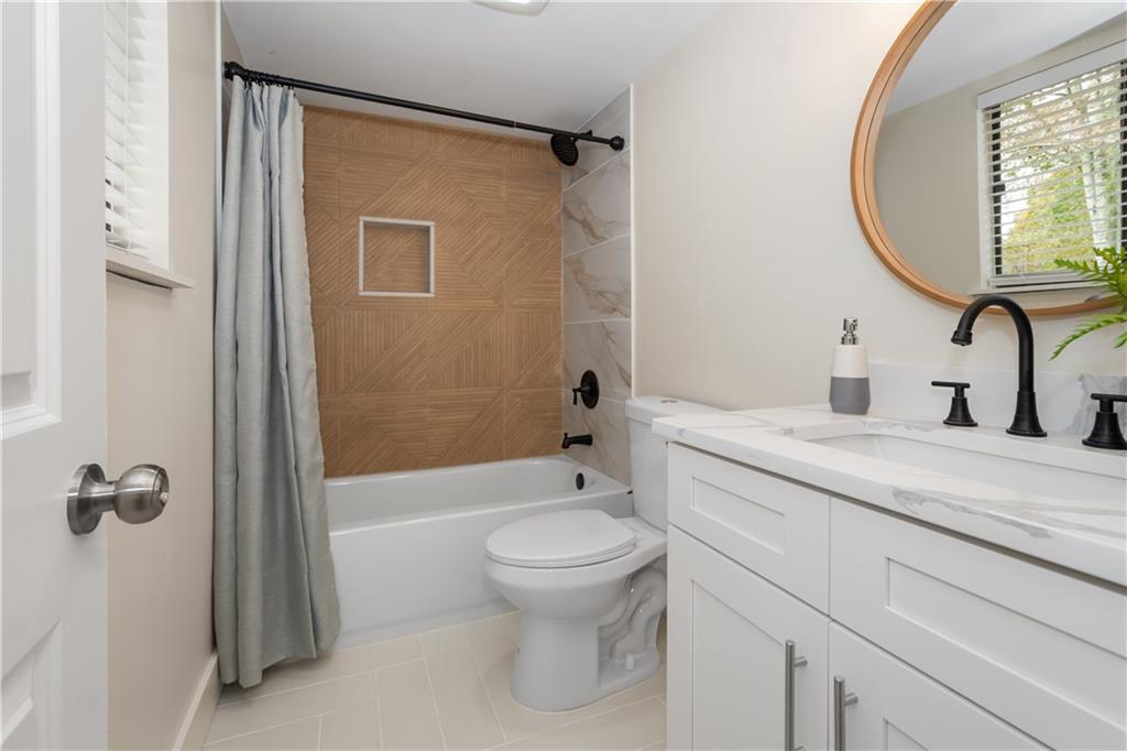 2432 Mistletoe Lane Southwest Snellville, GA 30039 - Photo 36 of 42 a bathroom with a granite countertop sink toilet and shower