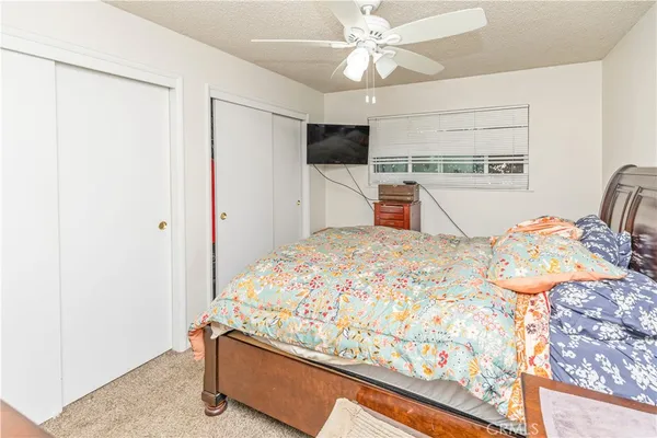 a bedroom with a bed and a flat tv screen on the dresser