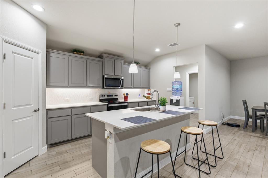 333 Alice Harney Road Burleson, TX 76028 - Photo 2 of 36 a kitchen that has a sink a counter space and stainless steel appliances