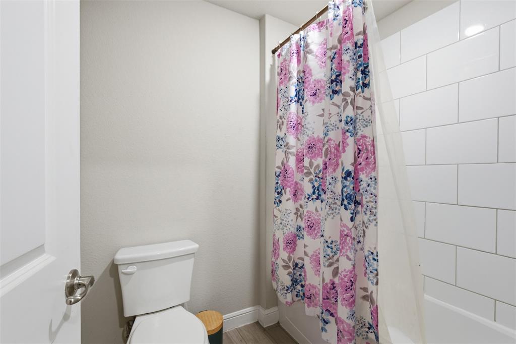 333 Alice Harney Road Burleson, TX 76028 - Photo 24 of 36 a white toilet sitting next to a shower curtain