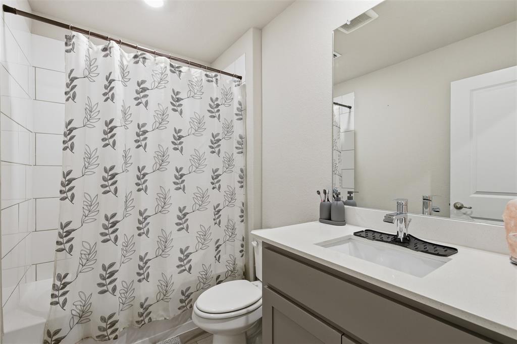 333 Alice Harney Road Burleson, TX 76028 - Photo 27 of 36 a bathroom with a granite countertop sink a toilet and a mirror