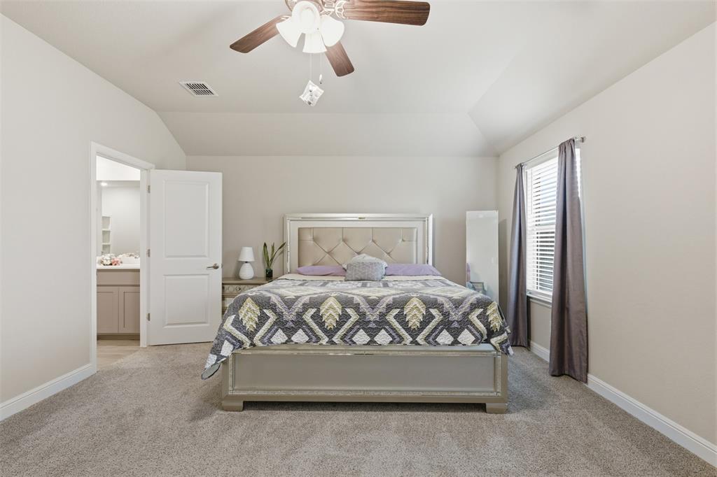 333 Alice Harney Road Burleson, TX 76028 - Photo 9 of 36 a bed sitting in a bedroom next to a window and a chandelier