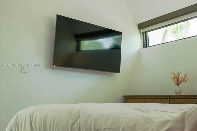 a bedroom with a bed and a flat screen tv