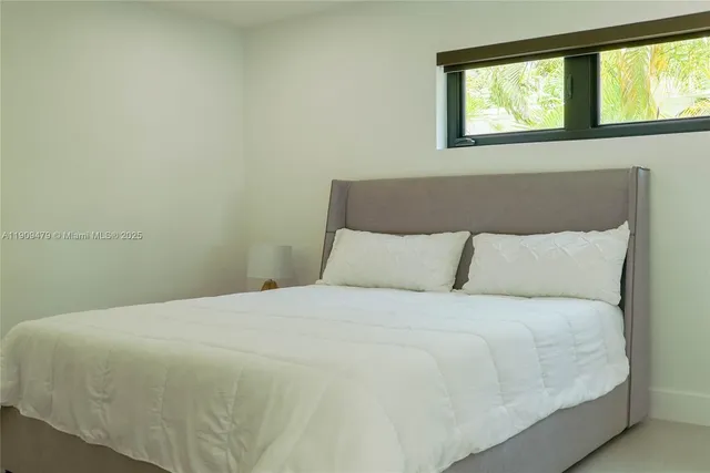 a large bed sitting in a bedroom next to a window