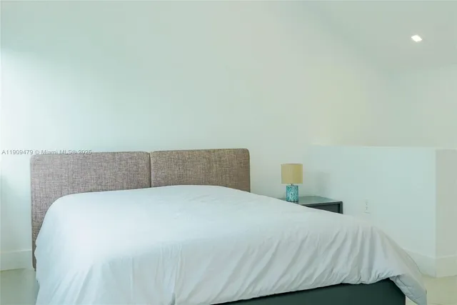 a bedroom with a bed and a night stand