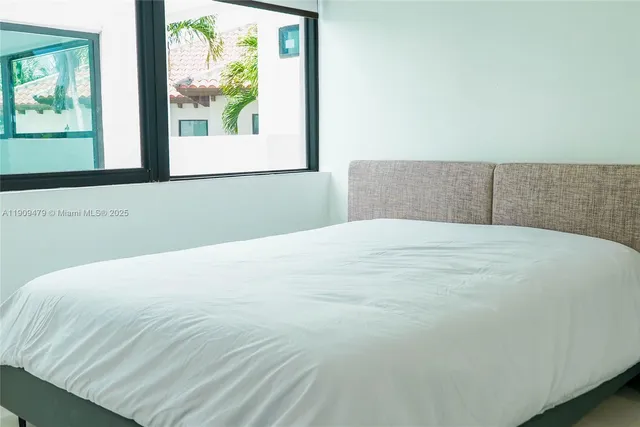 a bedroom with a bed and a large window