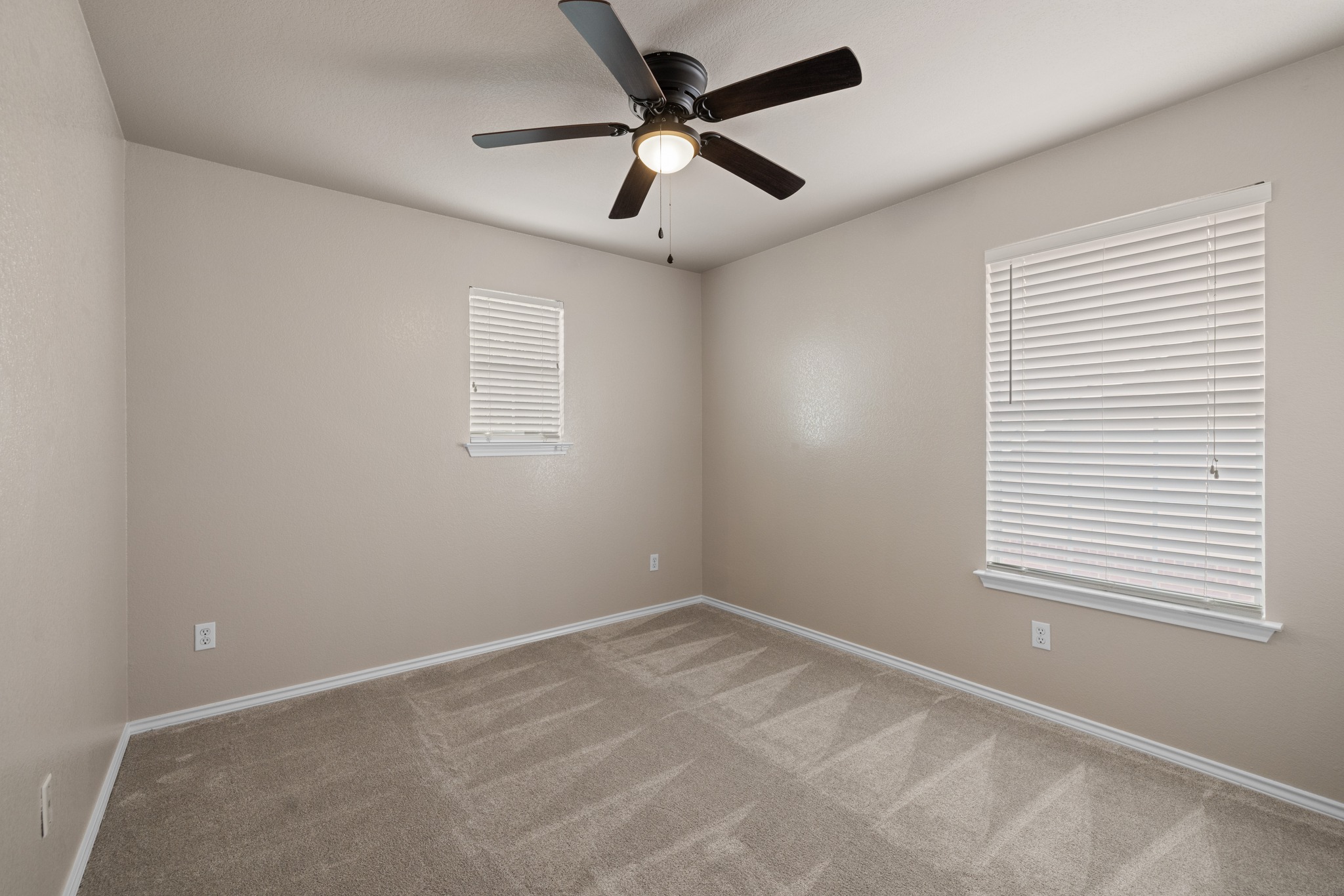 403 Red Hawk Drive Leander, TX 78641 - Photo 25 of 37 Carpeted room featuring a ceiling fan with integrated lighting, two windows with blinds, and neutral-toned walls