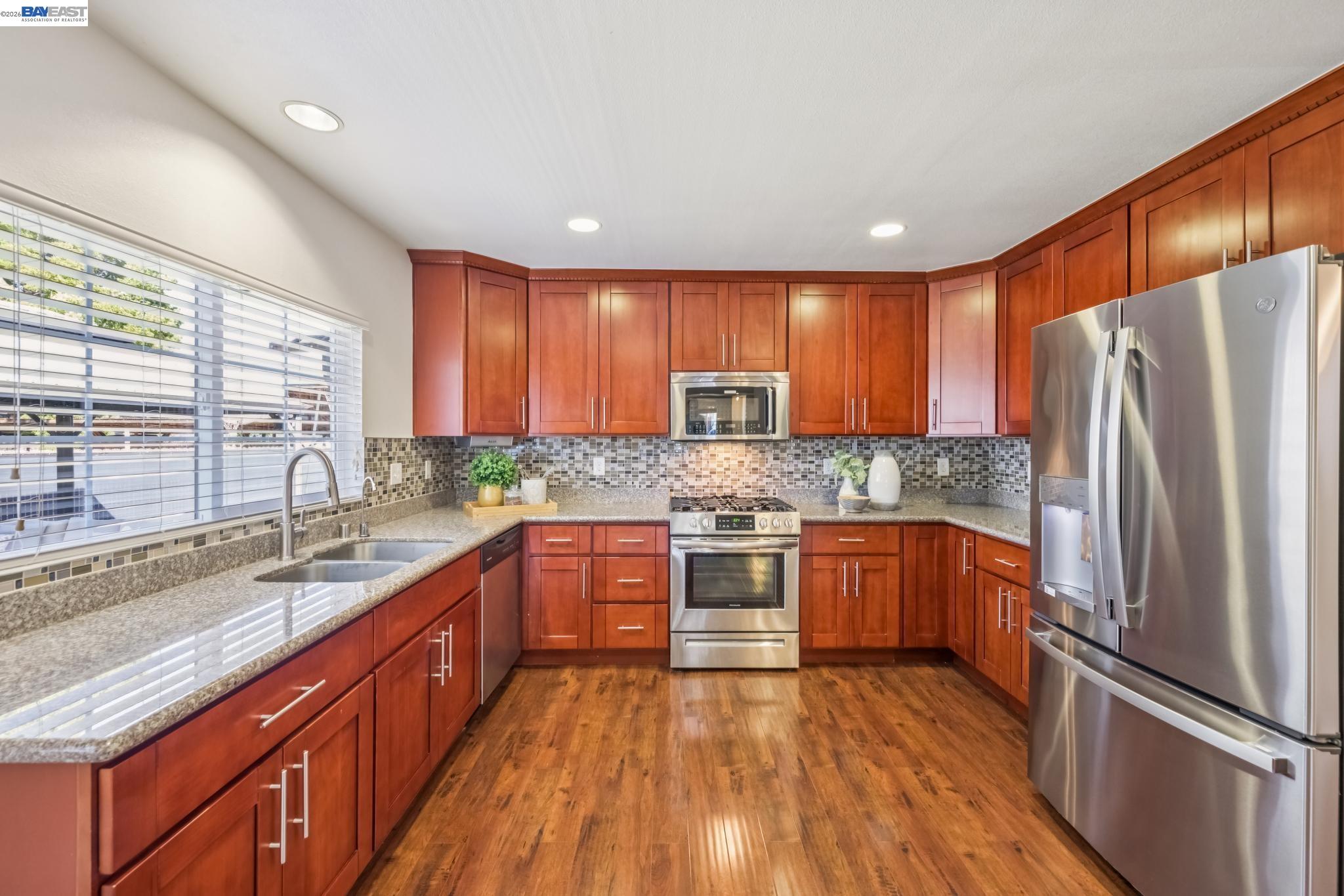 21132 Tyee Court Castro Valley, CA 94546 - Photo 12 of 60 a large kitchen with stainless steel appliances granite countertop a refrigerator a sink dishwasher a stove and wooden floors