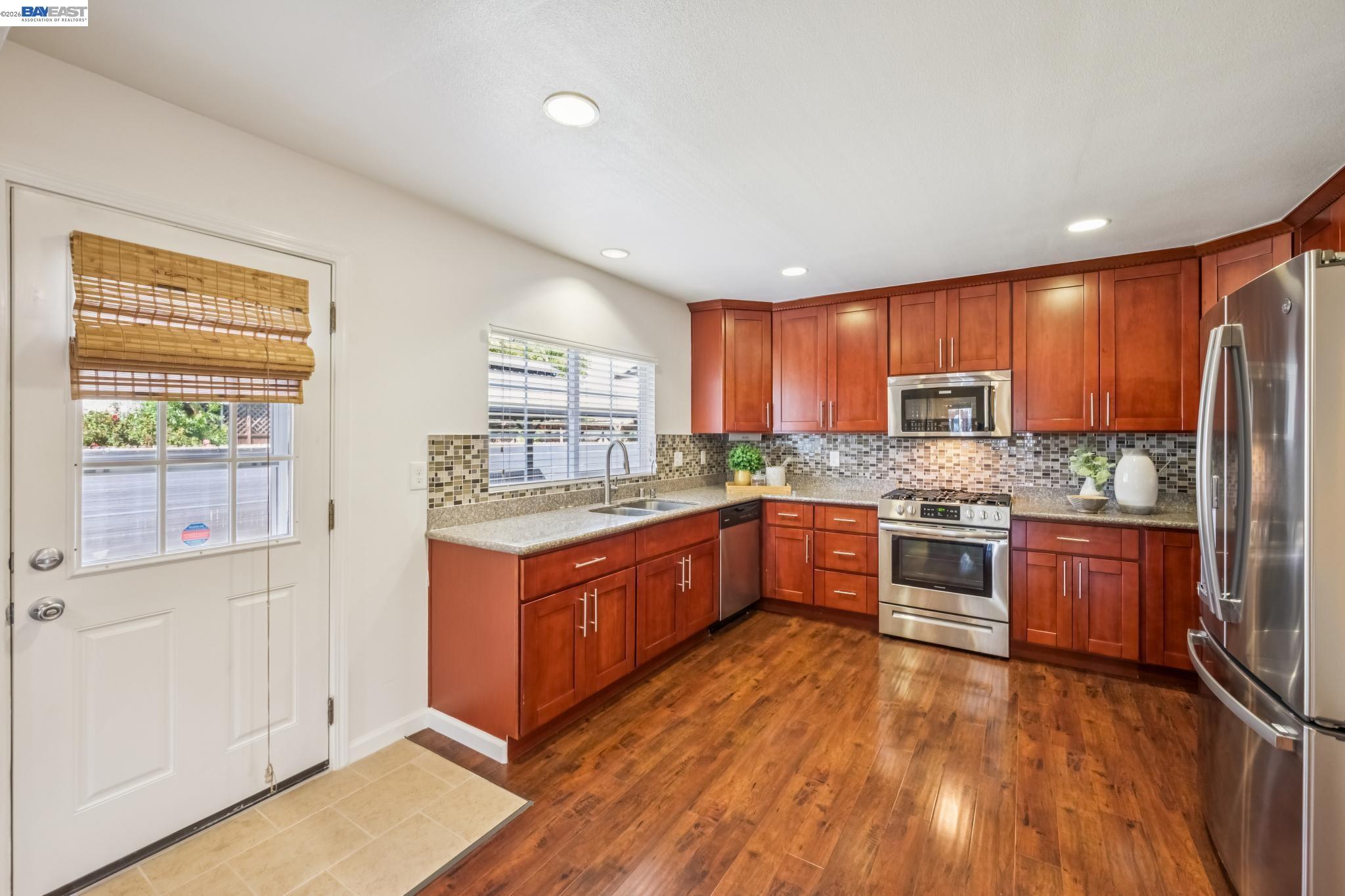 21132 Tyee Court Castro Valley, CA 94546 - Photo 13 of 60 a large kitchen with stainless steel appliances granite countertop wooden cabinets a stove a sink and a large window
