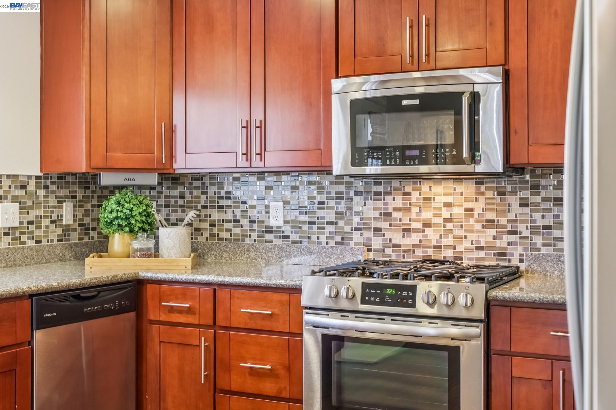21132 Tyee Court Castro Valley, CA 94546 - Photo 14 of 60 a kitchen with granite countertop a stove top oven microwave and cabinets
