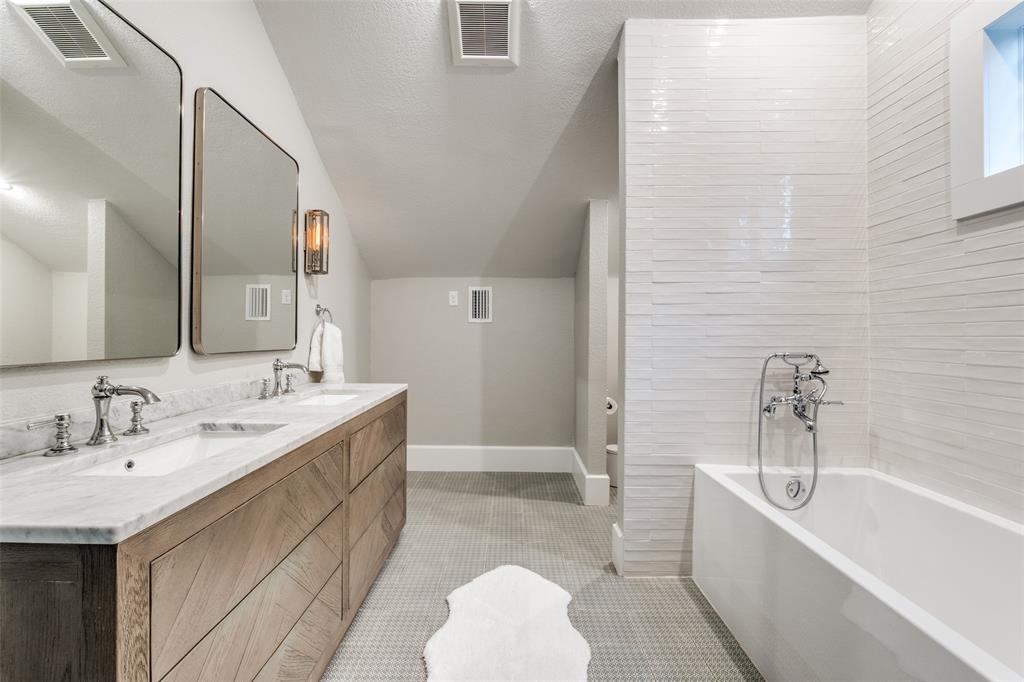 5235 Goodwin Avenue Dallas, TX 75206 - Photo 22 of 31 a bathroom with a double vanity sink a mirror and a bathtub
