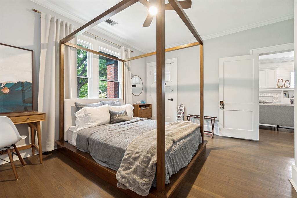 5235 Goodwin Avenue Dallas, TX 75206 - Photo 24 of 31 a bedroom with a bed a table and large mirror with a flat tv screen