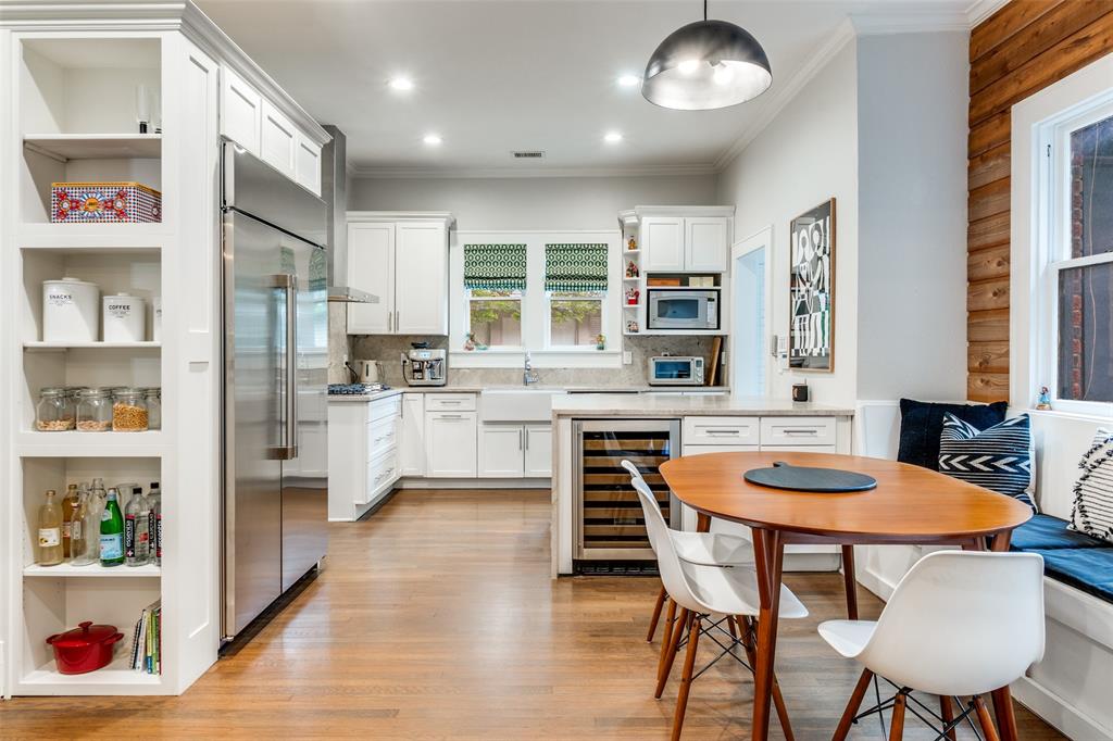 5235 Goodwin Avenue Dallas, TX 75206 - Photo 8 of 31 a kitchen with stainless steel appliances granite countertop a stove a refrigerator and a dining table with wooden floor