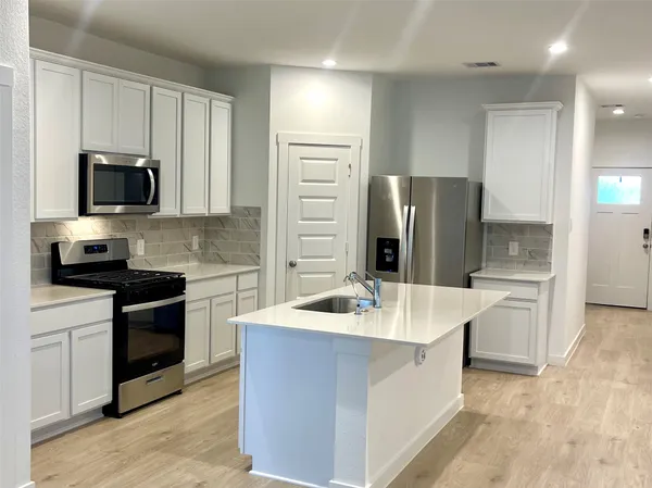 a kitchen with a sink stove and refrigerator