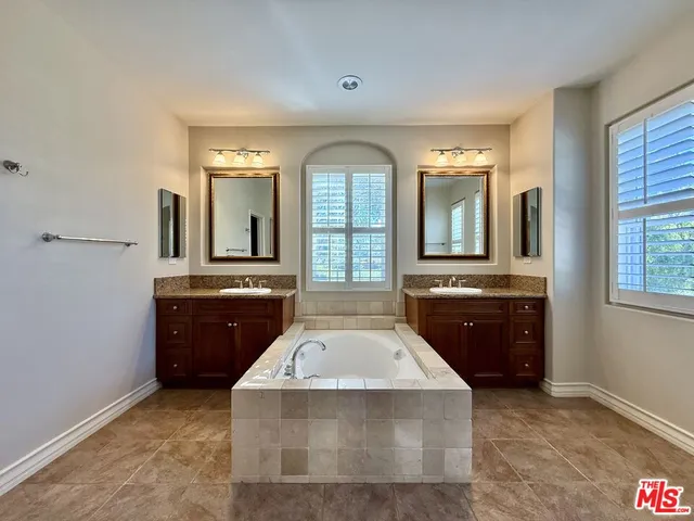 a spacious bathroom with a granite countertop tub sink and mirror