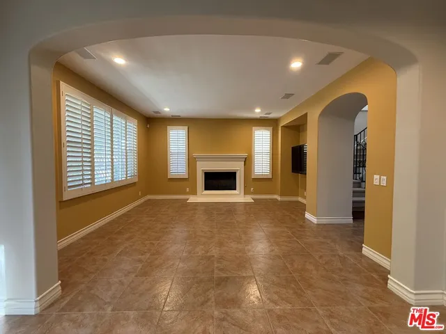 a view of an empty room with a fireplace and a window