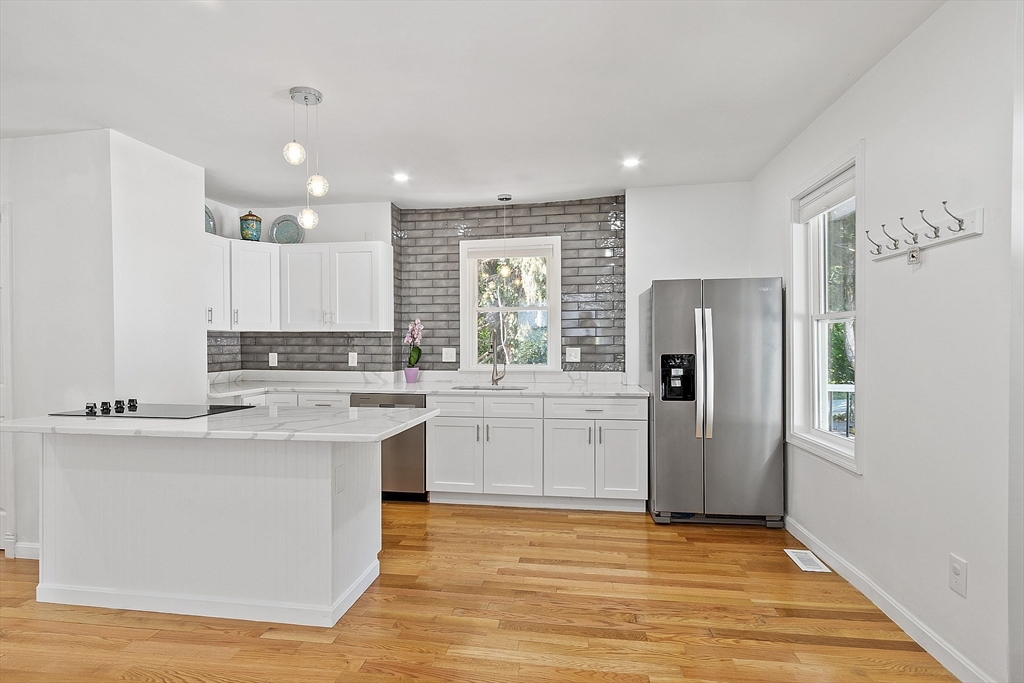 10 Burnham Road Andover, MA 01810 - Photo 3 of 25 a kitchen with stainless steel appliances granite countertop a refrigerator a sink dishwasher a stove and white countertops with wooden floor