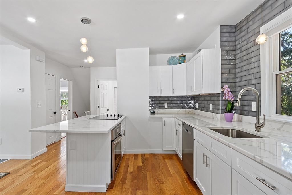 10 Burnham Road Andover, MA 01810 - Photo 4 of 25 a large white kitchen with kitchen island a sink stainless steel appliances and cabinets