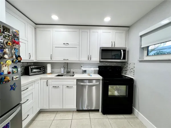 a kitchen with granite countertop a stove top oven sink and cabinets