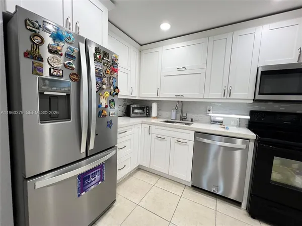 a kitchen with stainless steel appliances granite countertop a refrigerator sink and stove