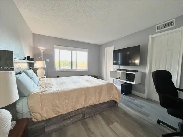 a spacious bedroom with a bed and a television