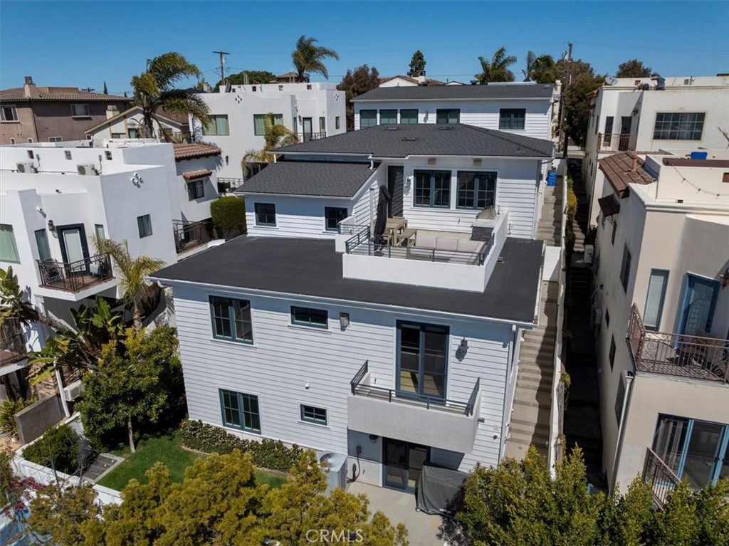 South facing patio with built in kitchen off main living area, deck of primary suite and lower grassy back yard
