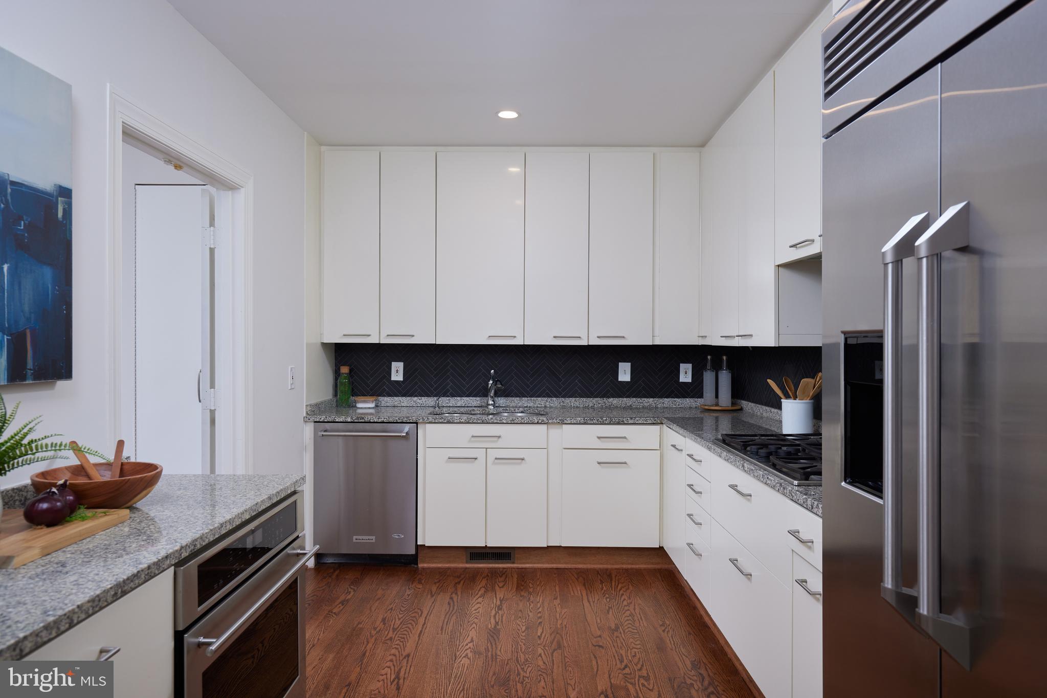 1802 Kalorama Square, Unit 16 Washington, DC 20008 - Photo 22 of 58 a kitchen with a sink dishwasher a refrigerator and white cabinets with wooden floor